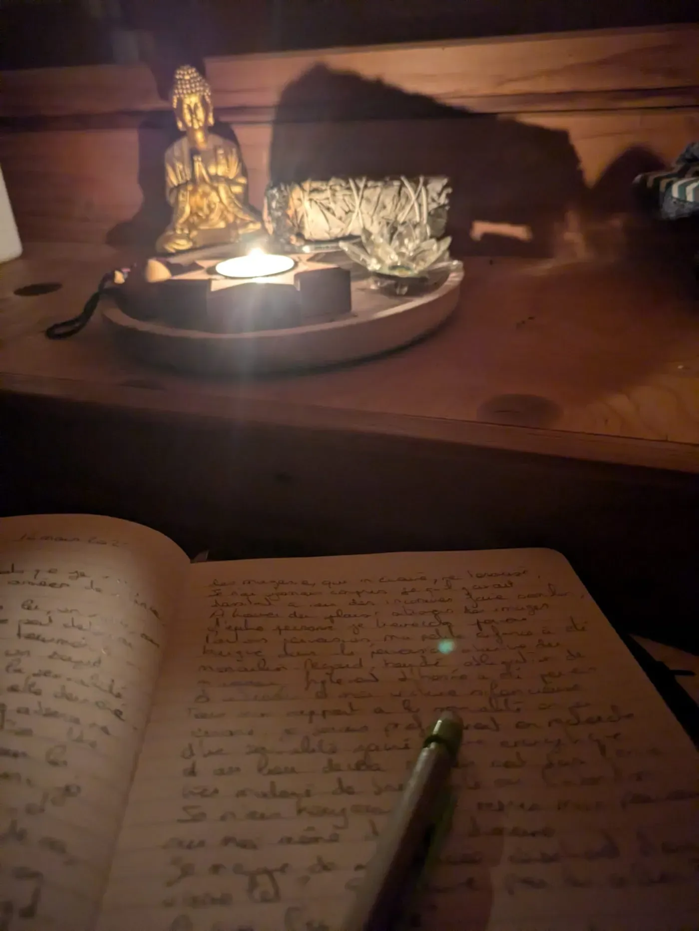 Un carnet manuscrit ouvert à la lueur d'une bougie.
