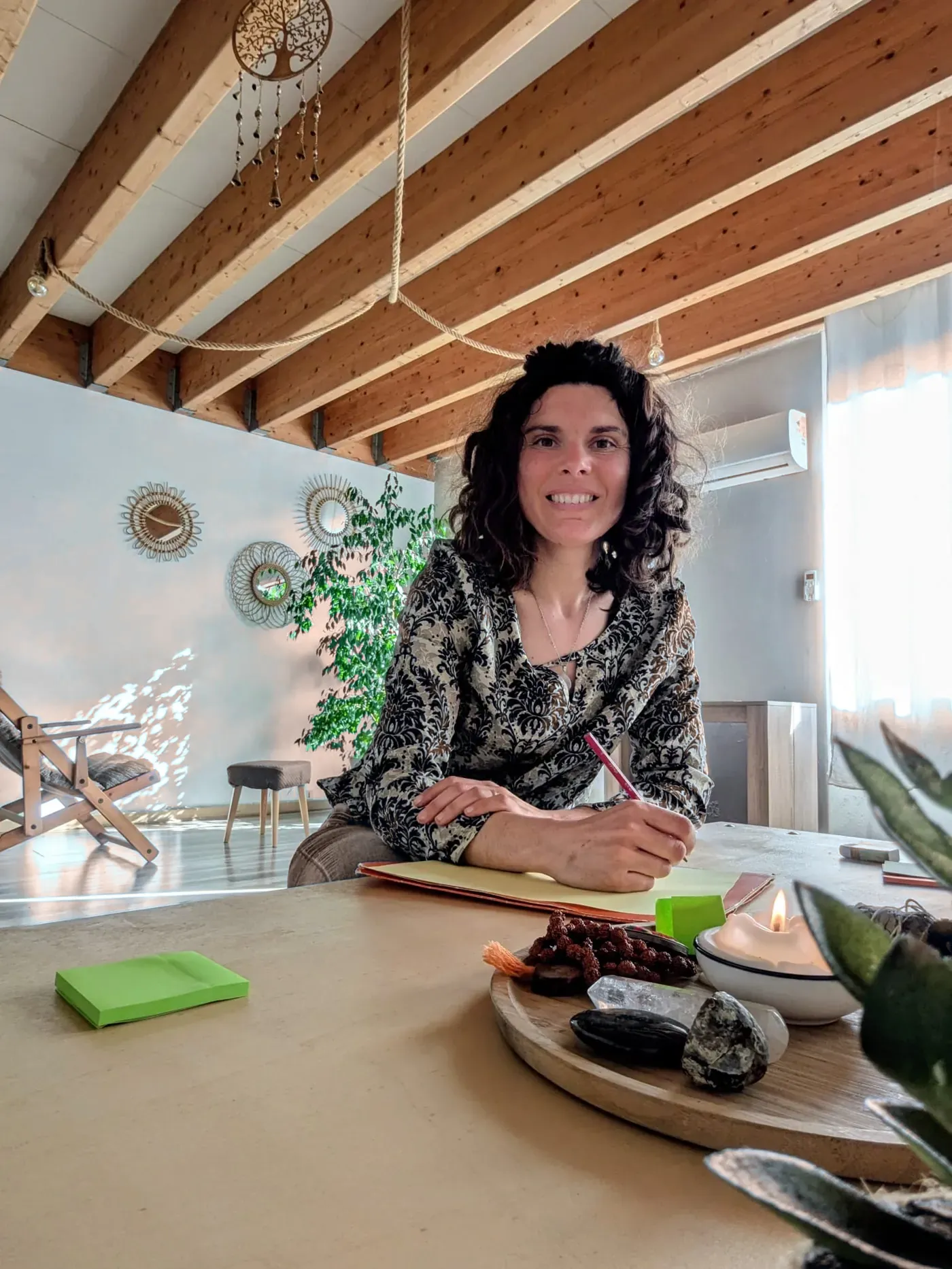 Sandrine, souriante, assise à son bureau dans son cabinet.