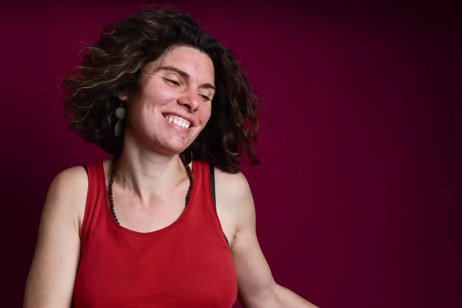 Sandrine Gnerucci Robbe, qui rit, en haut rouge sur fond grenat.